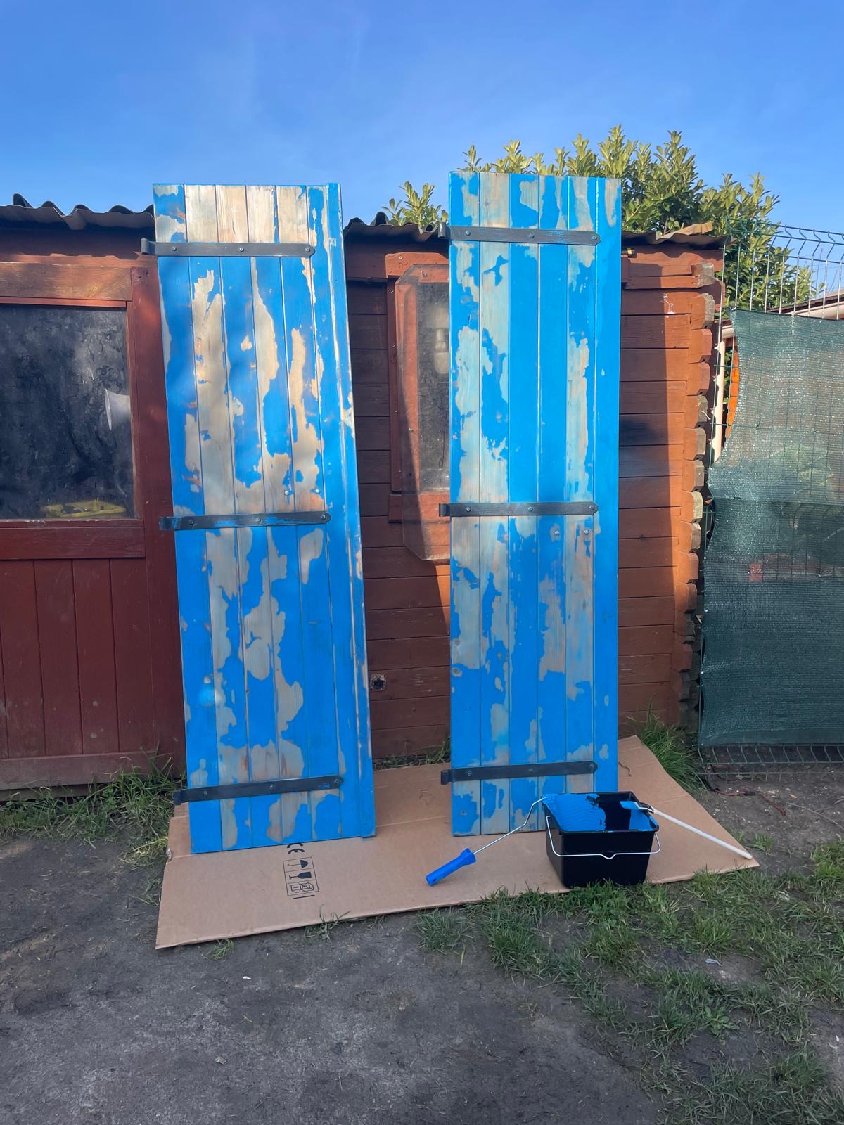 Volets en bois écaillés et poncés avant remise en peinture en Essonne