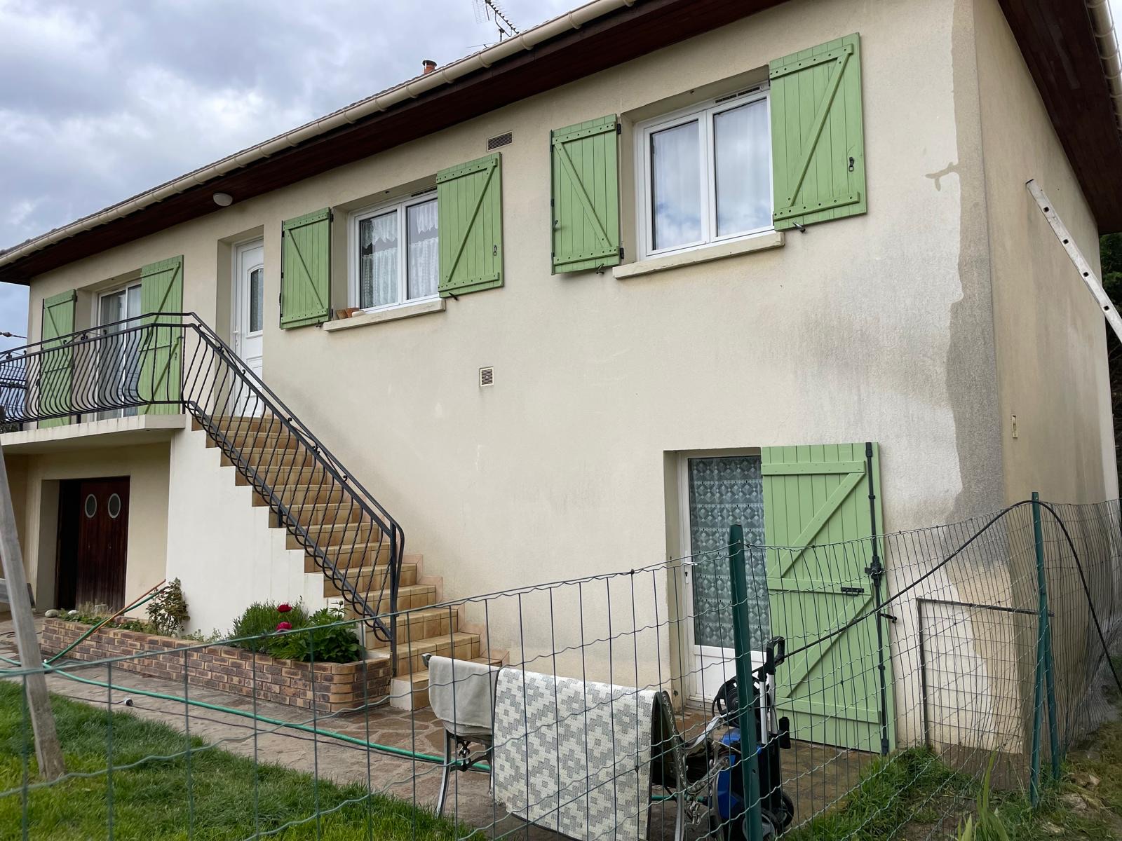 Ravalement de façade en cours sur une maison à volets verts en Essonne